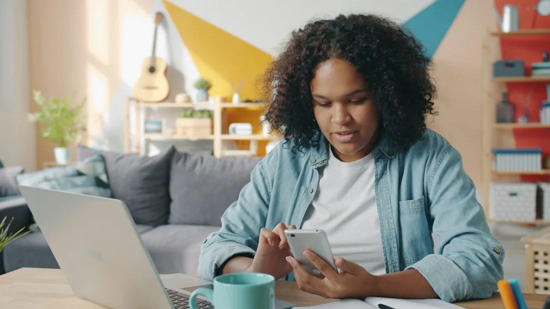 Student taking the online course on a laptop and phone